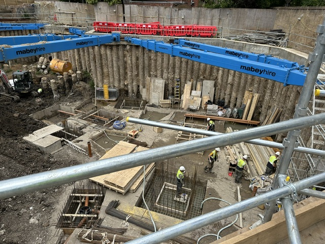 Aerial view of a secant pile wall excavation with temporary props and rebar cages