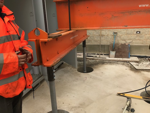 Steel waling beam being positioned for a ground anchor installation