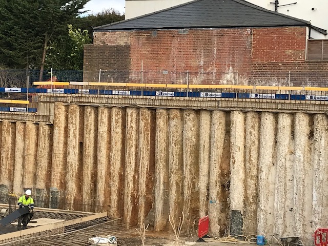 Close-up of a tall secant pile retaining wall